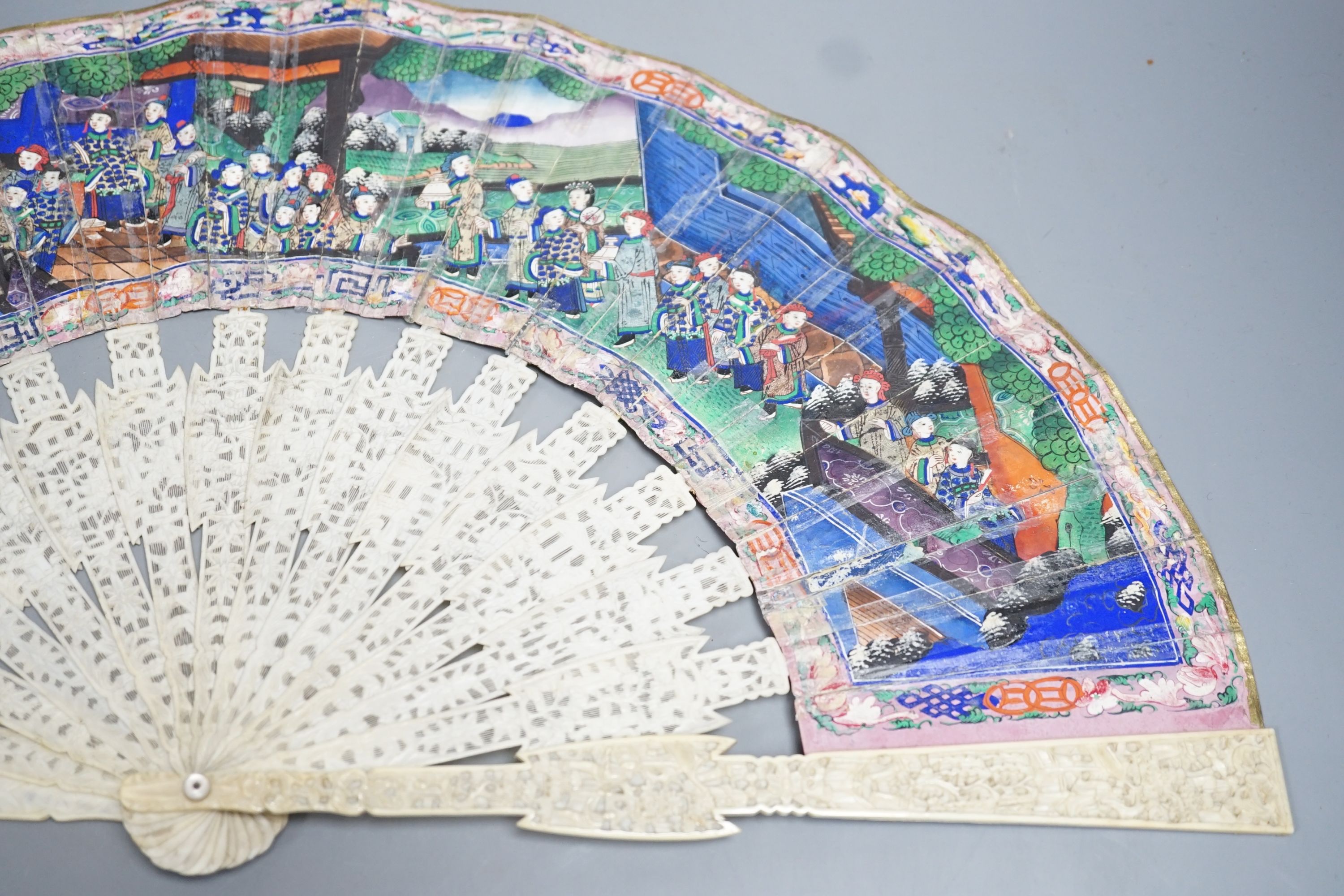 A 19th century Chinese export pierced ivory and painted paper leaf fan, in box. Fan 28cm long